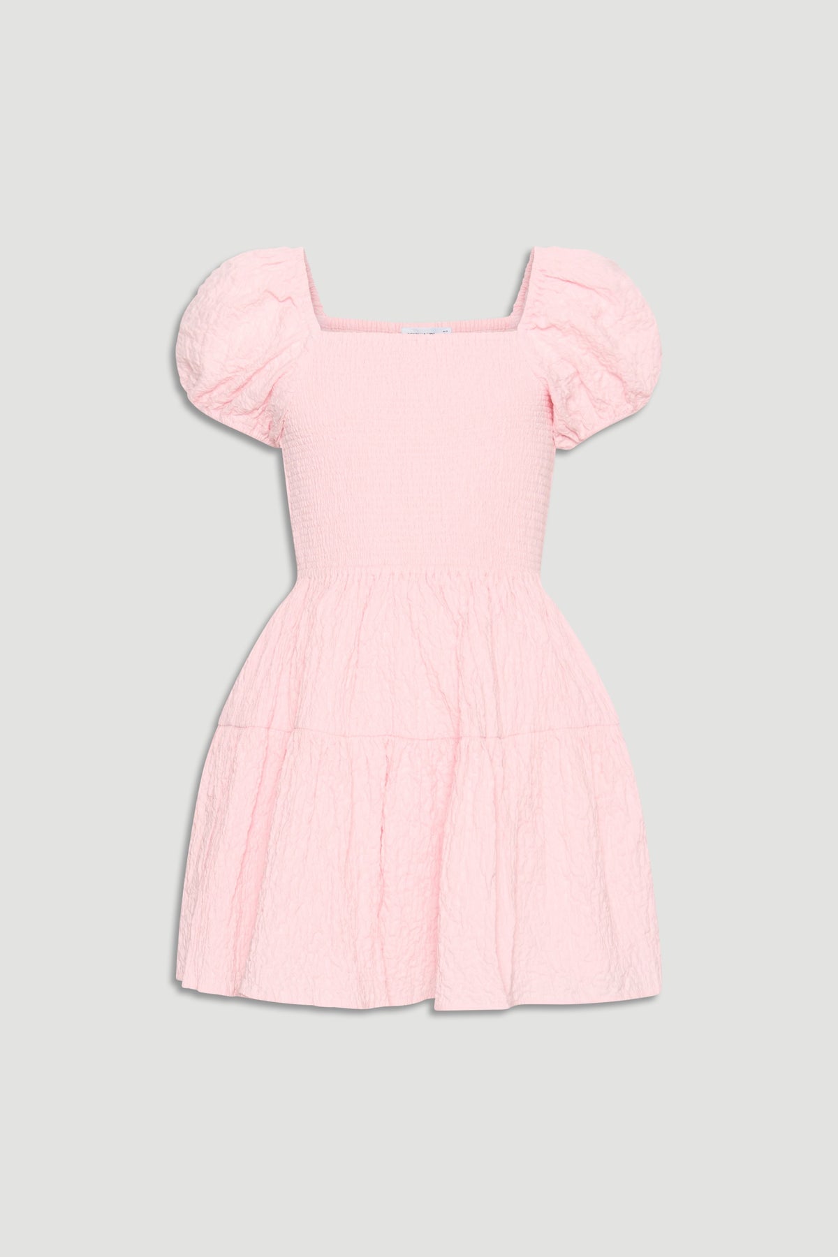 Light pink textured mini dress with smocked bodice, square neckline, and puffed short sleeves for girls.