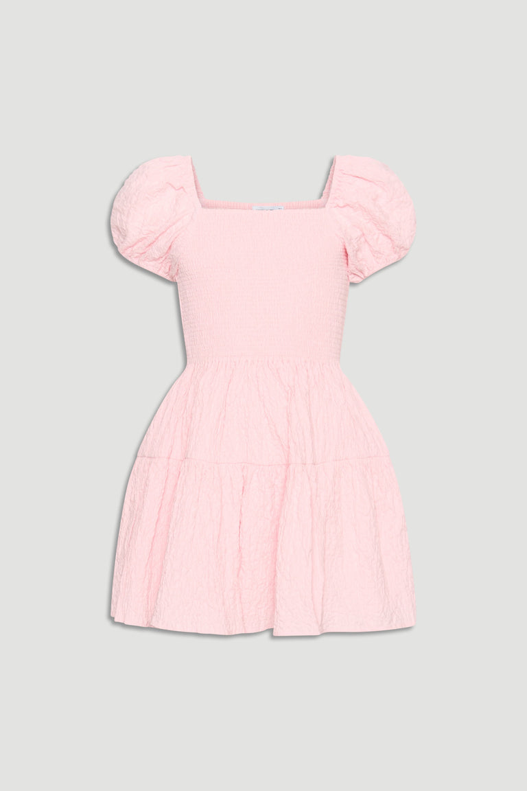 Light pink textured mini dress with smocked bodice, square neckline, and puffed short sleeves for girls.