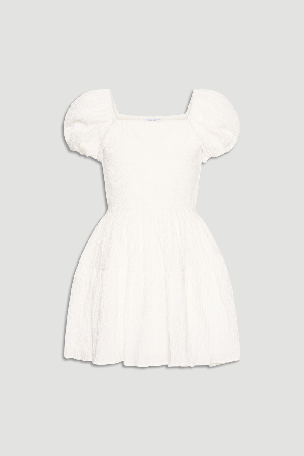 White mini dress for girls featuring puff sleeves, square neckline, and a flared, textured skirt for playful style.
