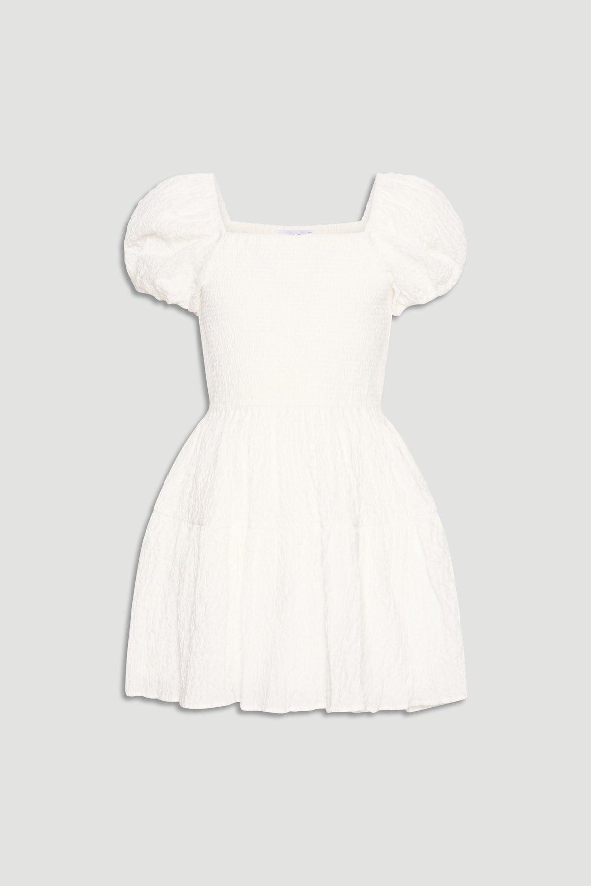 White mini dress for girls featuring puff sleeves, square neckline, and a flared, textured skirt for playful style.