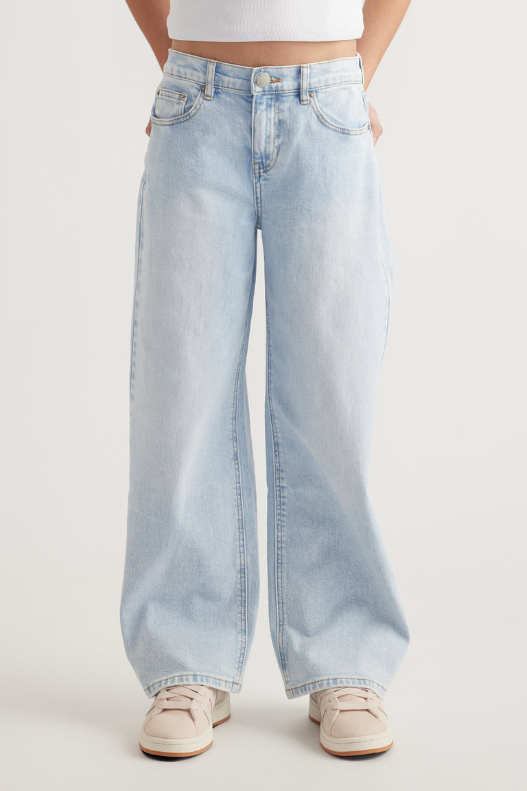 Front view of light wash baggy fit mid-rise jeans with zip fly and functional pockets worn with sneakers