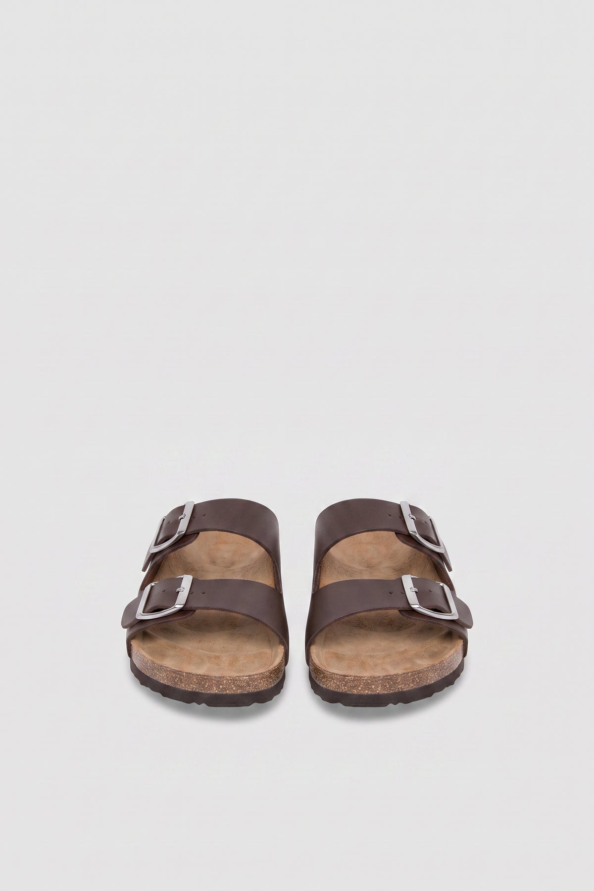 Pair of girls brown flat sandals with double buckle straps, silver hardware and cork soles