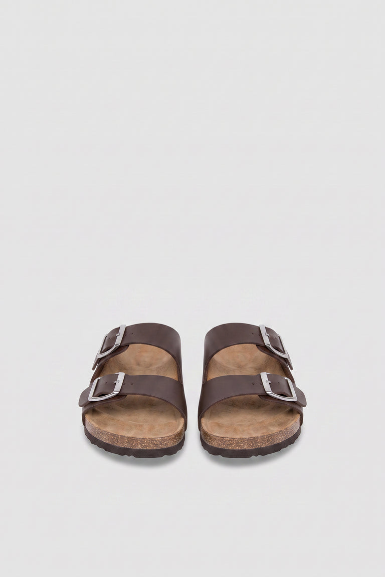 Pair of girls brown flat sandals with double buckle straps, silver hardware and cork soles