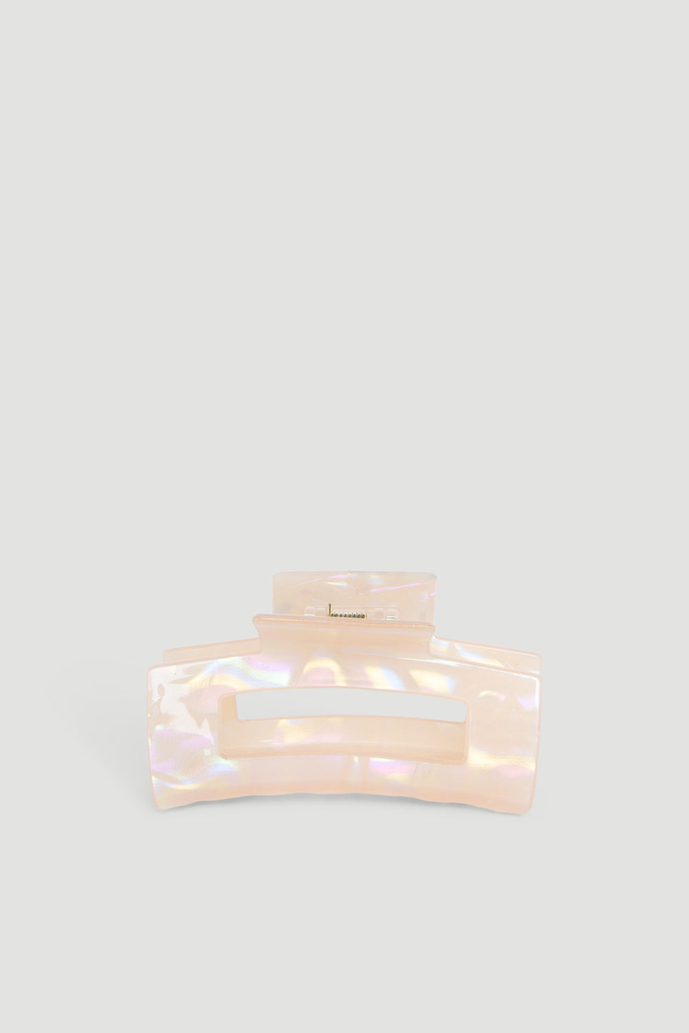 Iridescent peach-colored hair claw with a wide grip, designed for securing hair effortlessly.