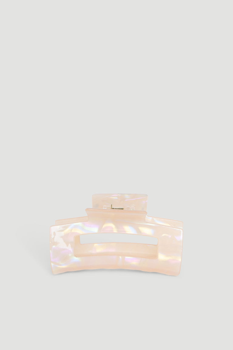 Iridescent peach-colored hair claw with a wide grip, designed for securing hair effortlessly.