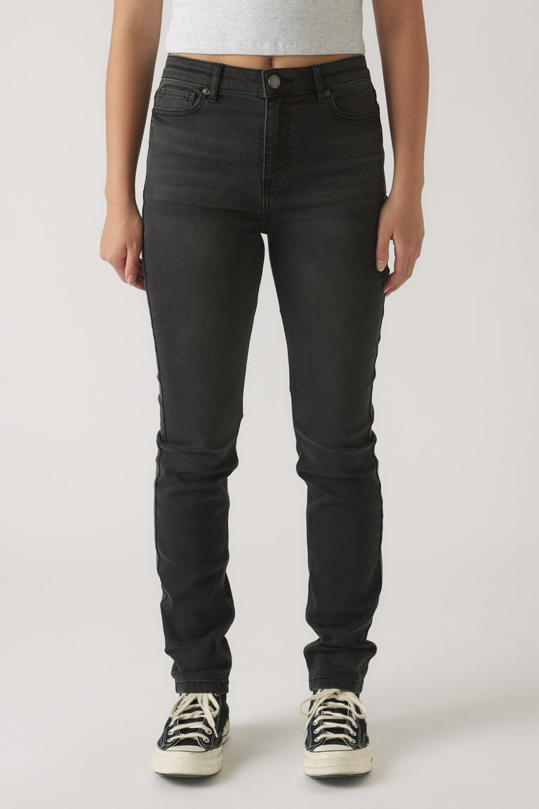 Front view of girls wearing black skinny leg denim jeans paired with casual black and white sneakers