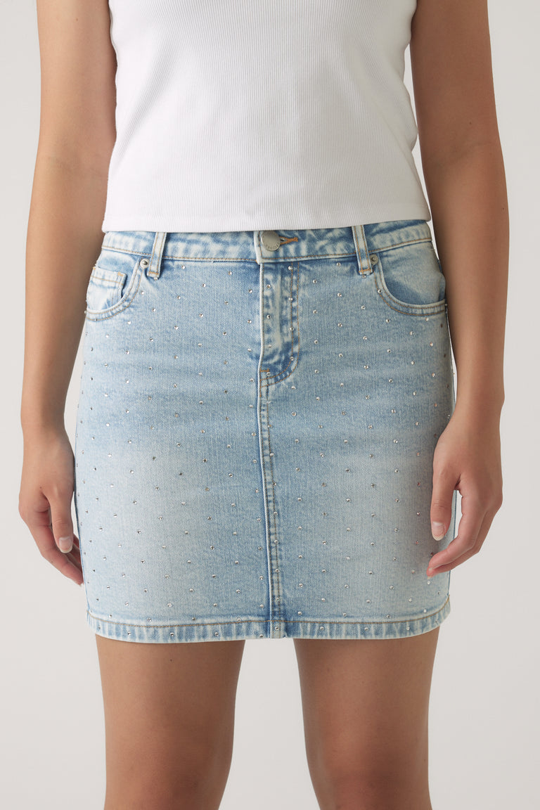 Light wash girls denim skirt with subtle embellishments, front pockets, and a straight, casual fit.