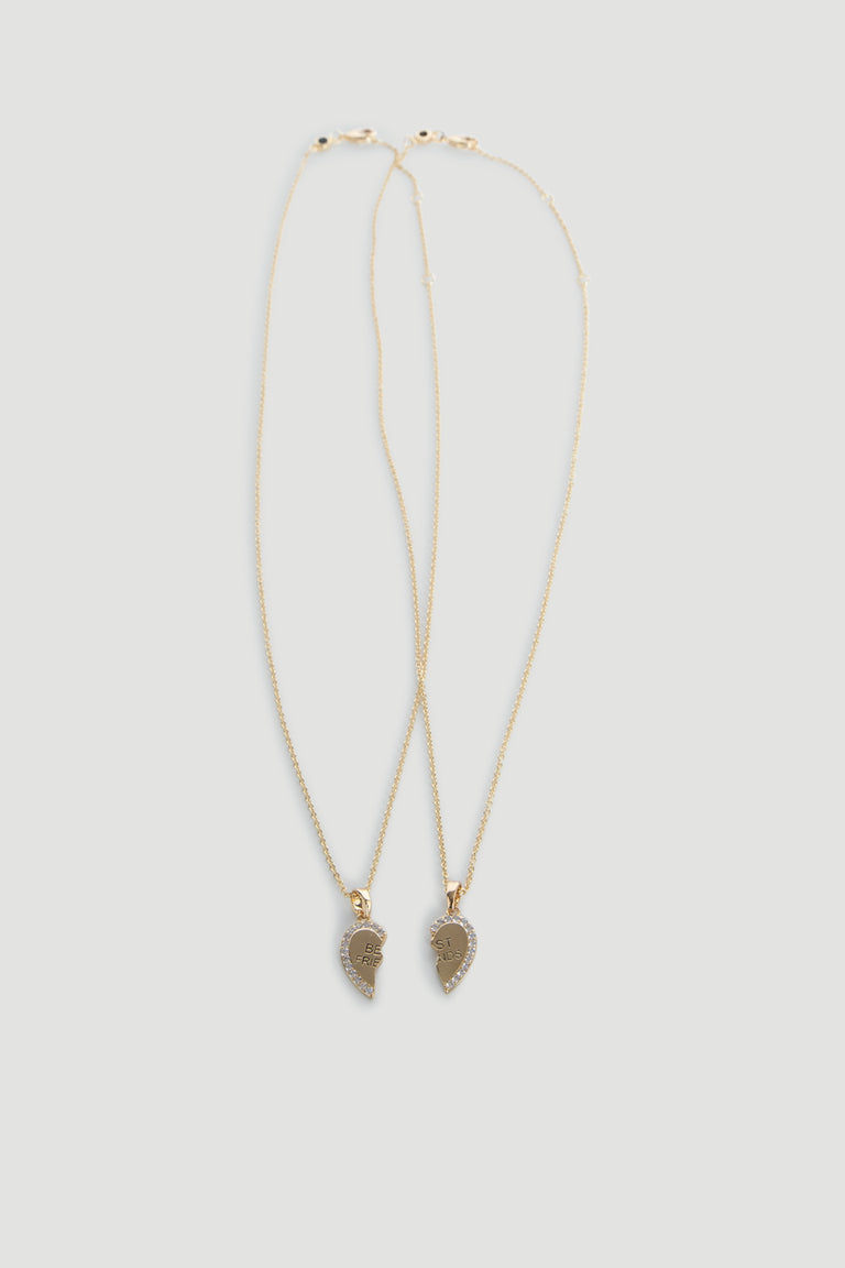 Two delicate gold necklaces featuring matching heart-shaped pendants designed as best friends keepsakes.