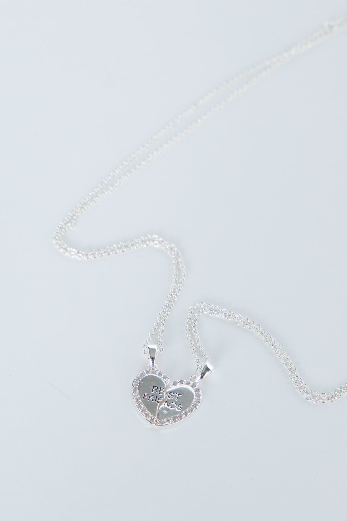 Delicate silver-tone heart pendant split into two best friends charms on matching fine chains