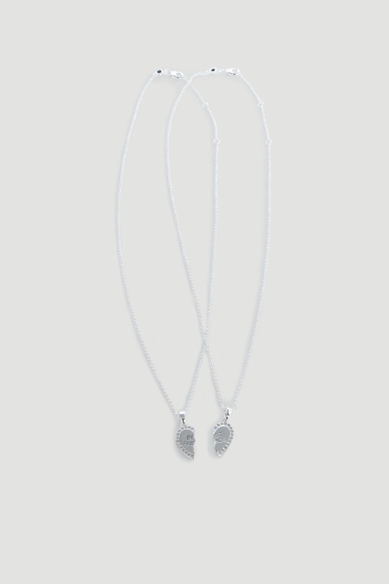 Two delicate silver necklaces each featuring half of a heart pendant engraved with "BFF" for best friends