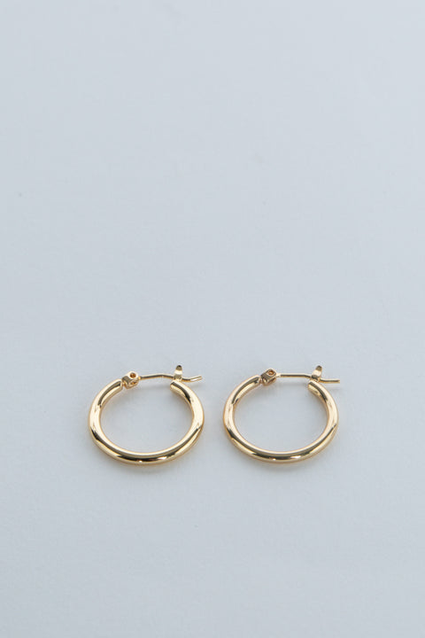 Pair of gold hoop earrings displayed on a pale blue background