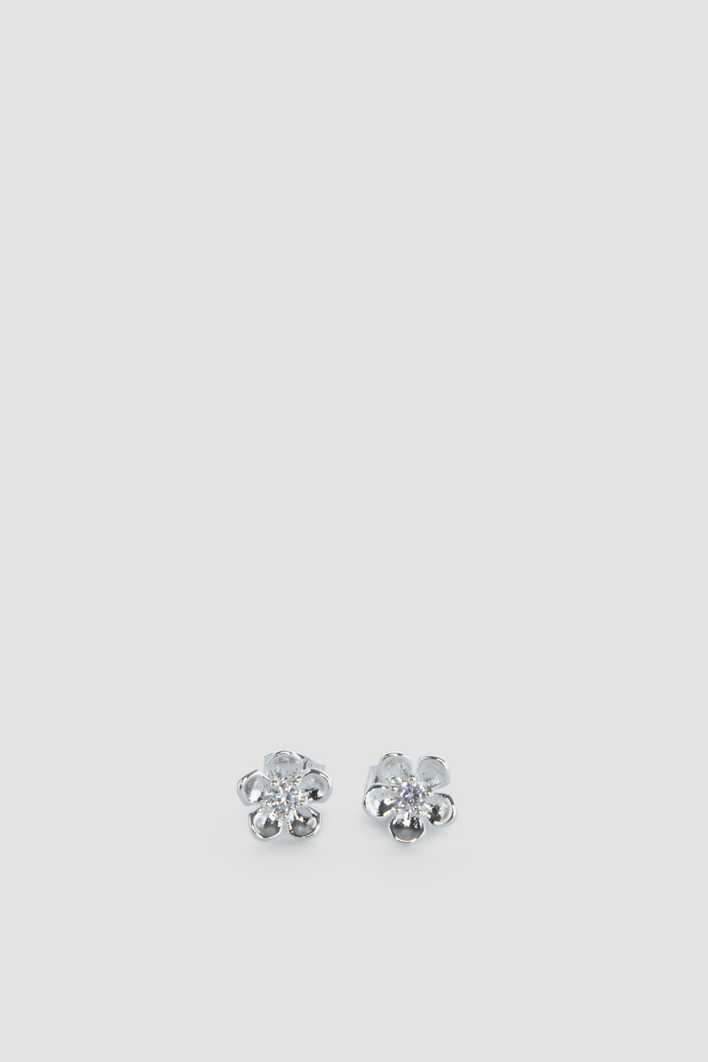Delicate silver flower-shaped stud earrings with sparkling centers, designed for effortless everyday wear.