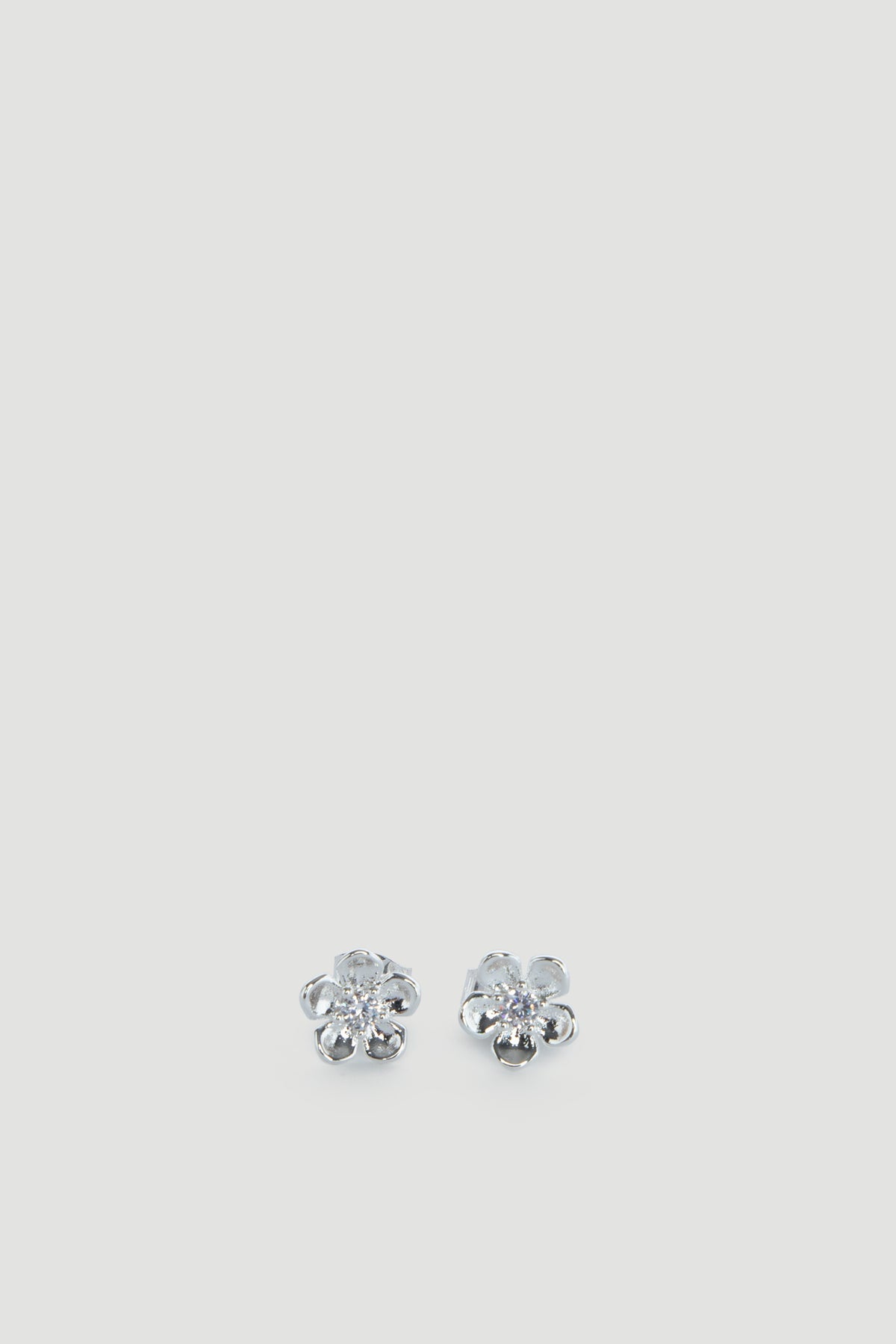 Delicate silver flower-shaped stud earrings with sparkling centers, designed for effortless everyday wear.