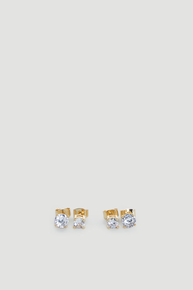 Two pairs of delicate gold stud earrings each featuring sparkling clear stones on a light grey background