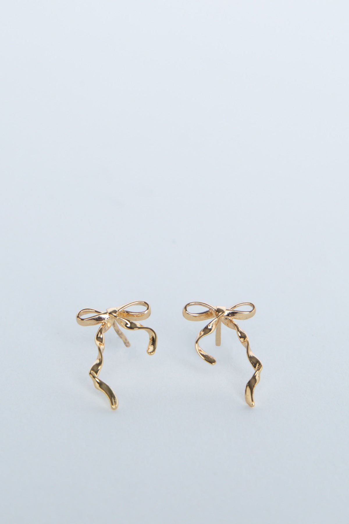 Delicate 9ct gold stud earrings shaped as elegant bows with flowing ribbon details for a subtle, charming look