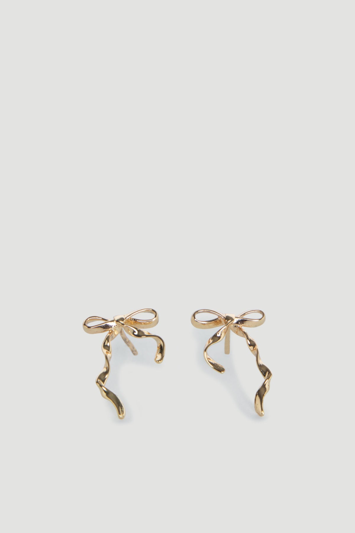 Delicate gold bow-shaped stud earrings with elegant twisting ribbon details for a charming, youthful look