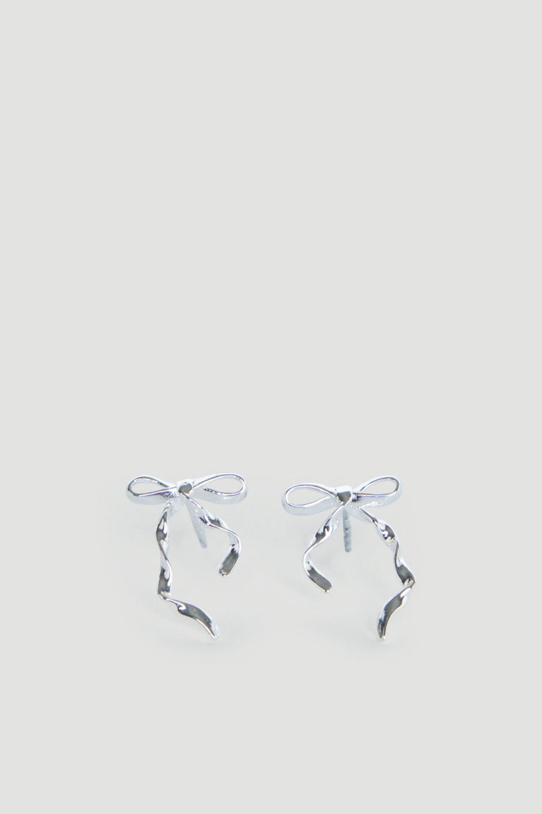 Delicate silver bow-shaped stud earrings with flowing ribbon details, designed for girls with a charming, graceful touch.