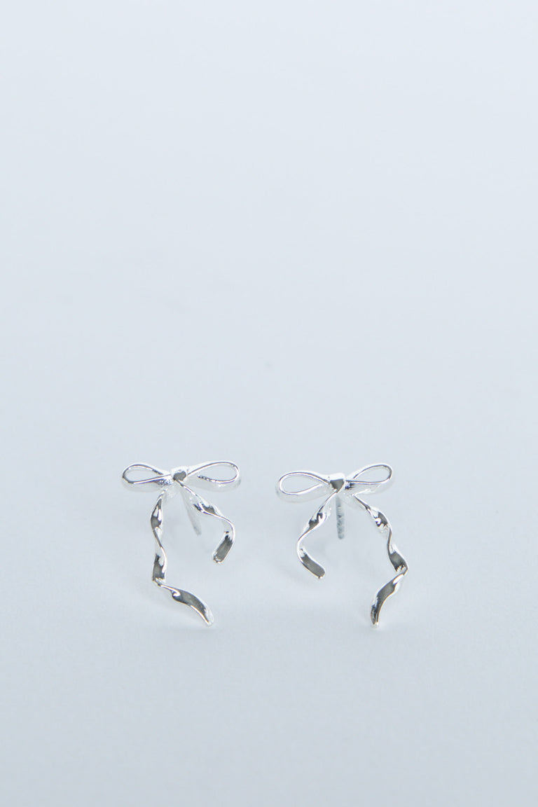 Delicate silver bow-shaped stud earrings with flowing ribbon details, perfect for adding a subtle touch of elegance.