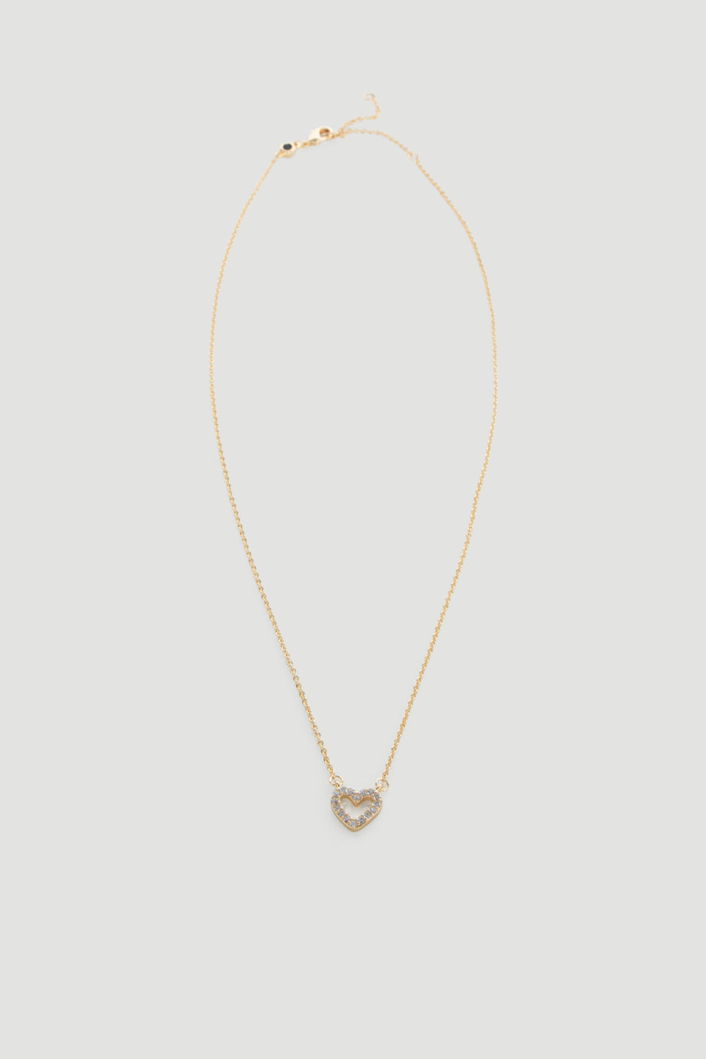 Delicate gold necklace featuring a small heart pendant adorned with sparkling stones for a subtle touch of elegance