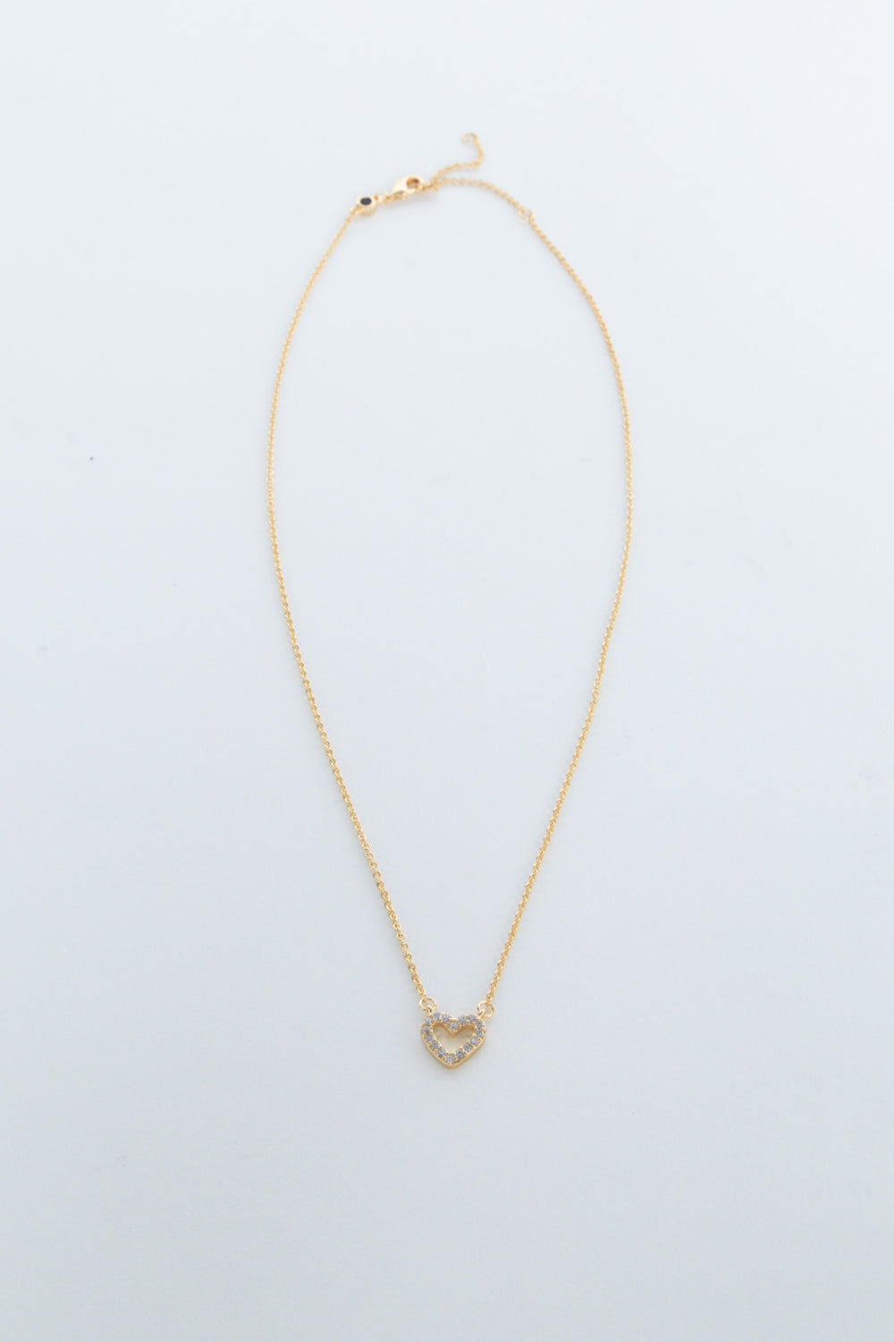 Delicate gold chain necklace featuring a small heart-shaped pendant with sparkling accents for girls.