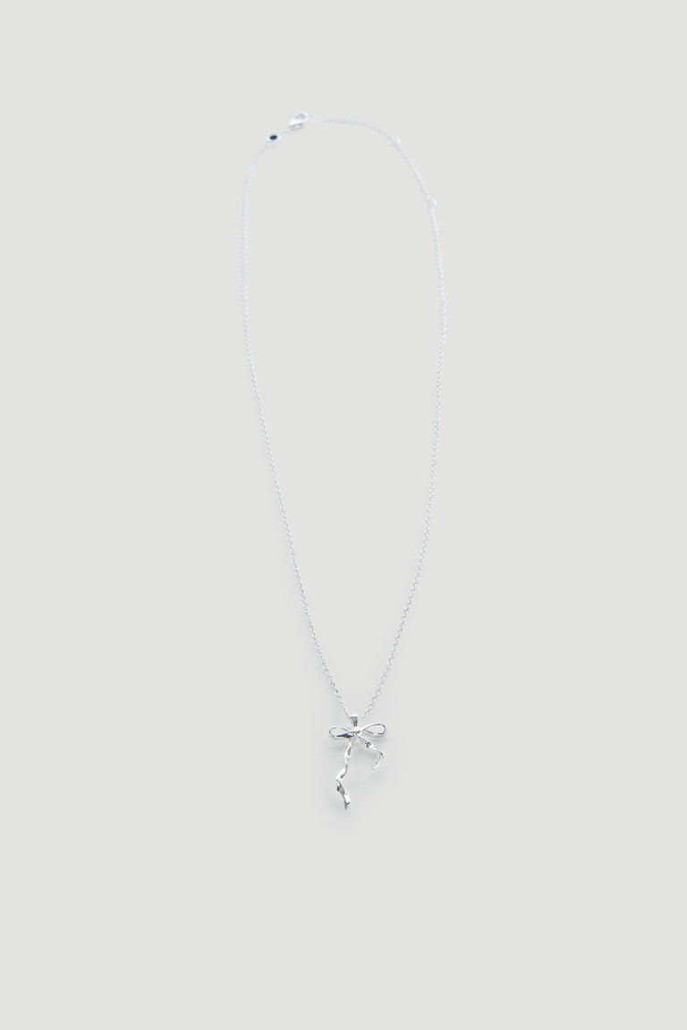 Delicate silver necklace featuring a dainty bow pendant on a fine chain, perfect for everyday wear.