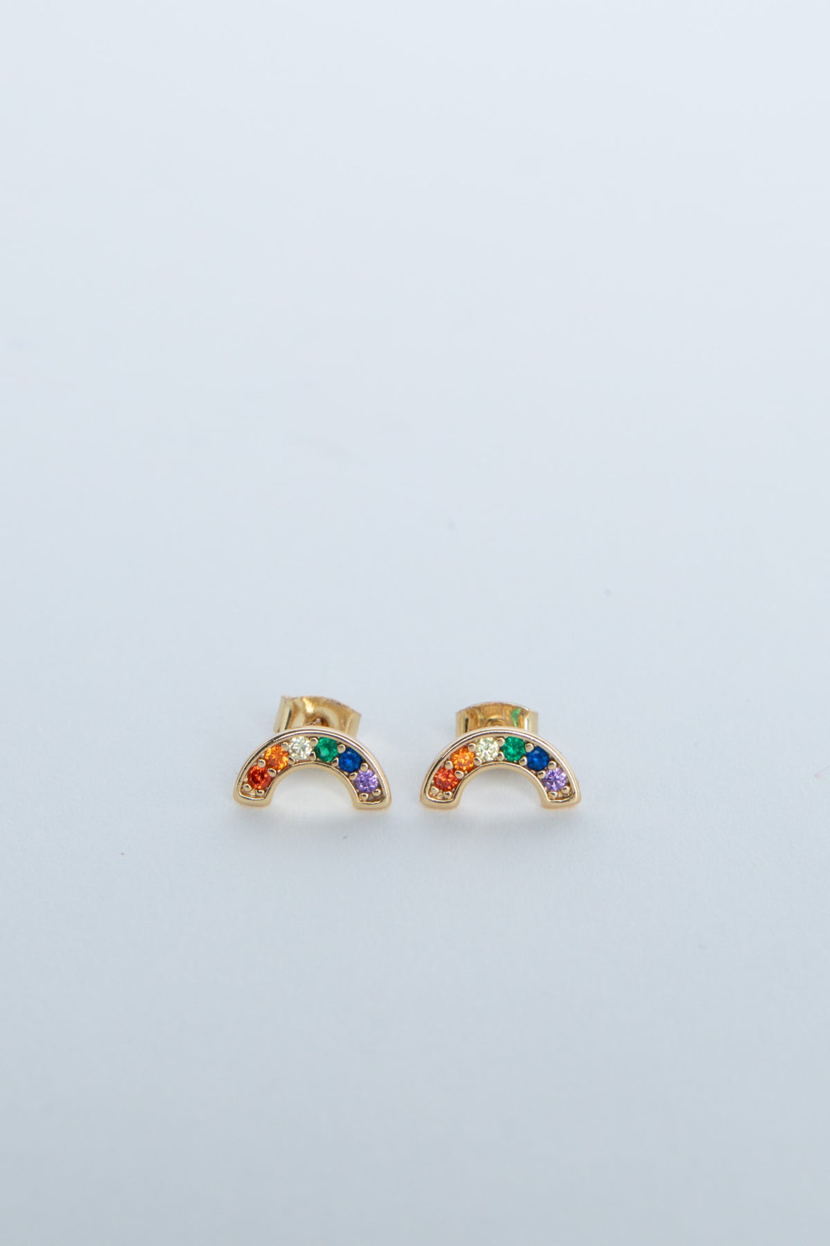 Small gold stud earrings shaped like rainbows with colorful gemstones in a delicate design for girls.