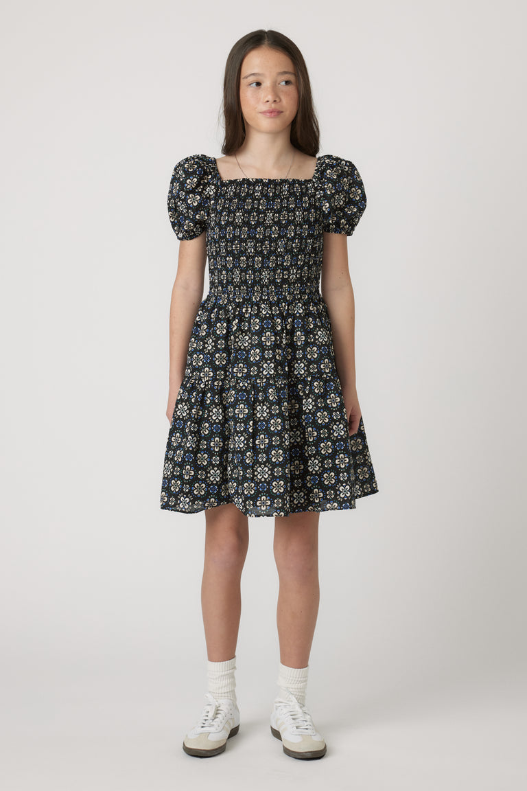 Girls Maude Mini Dress with short balloon sleeves and floral print, worn by model in portrait gallery position 1, 4060x6090px.