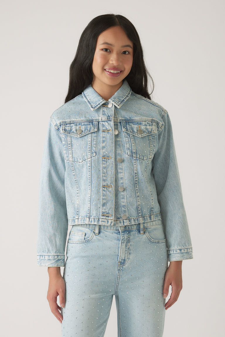 Girl wearing a light wash Girls Embellished Denim Jacket featuring subtle sparkling details for a stylish everyday look.