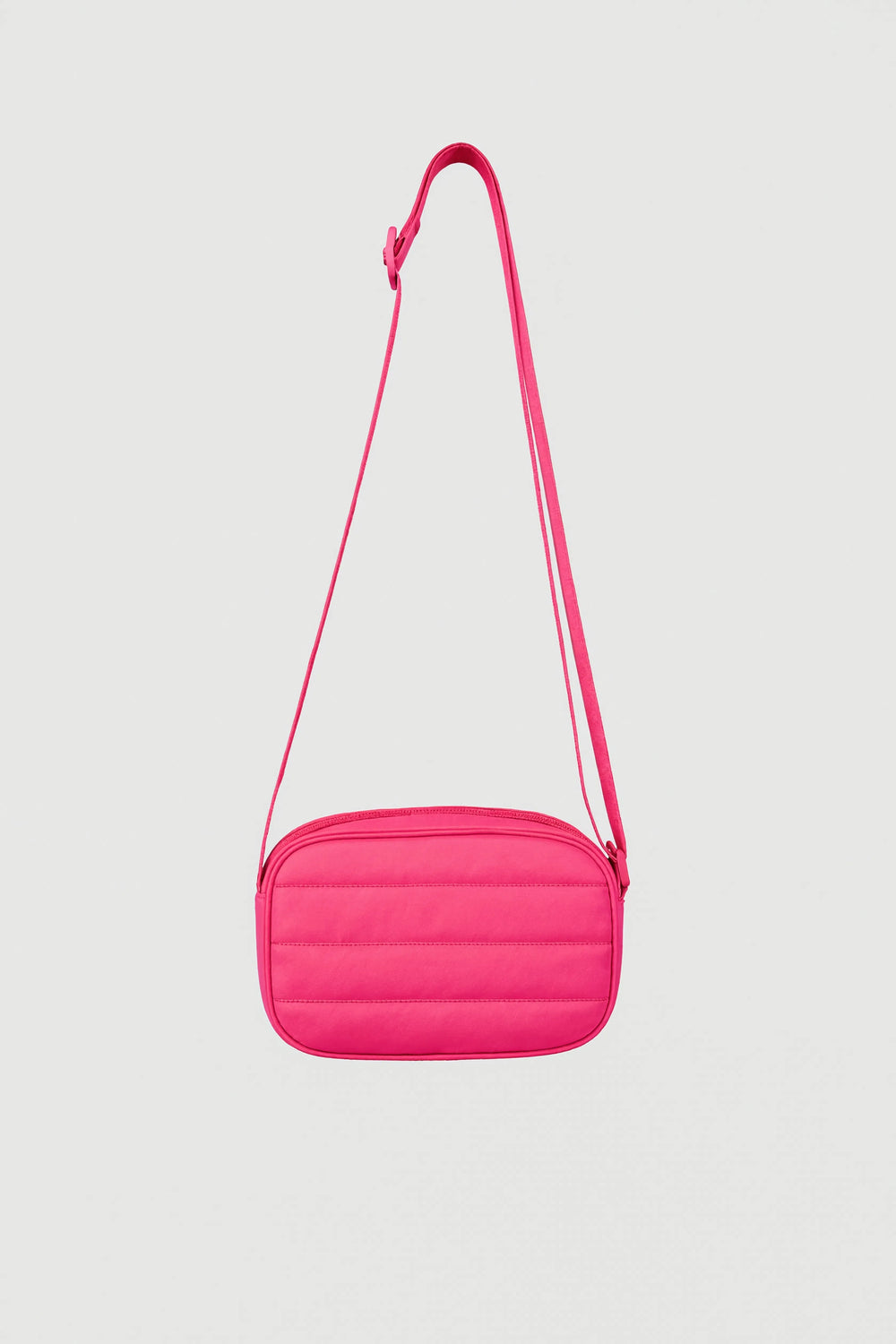 Bright pink padded crossbody bag with adjustable strap and zip closure against plain background
