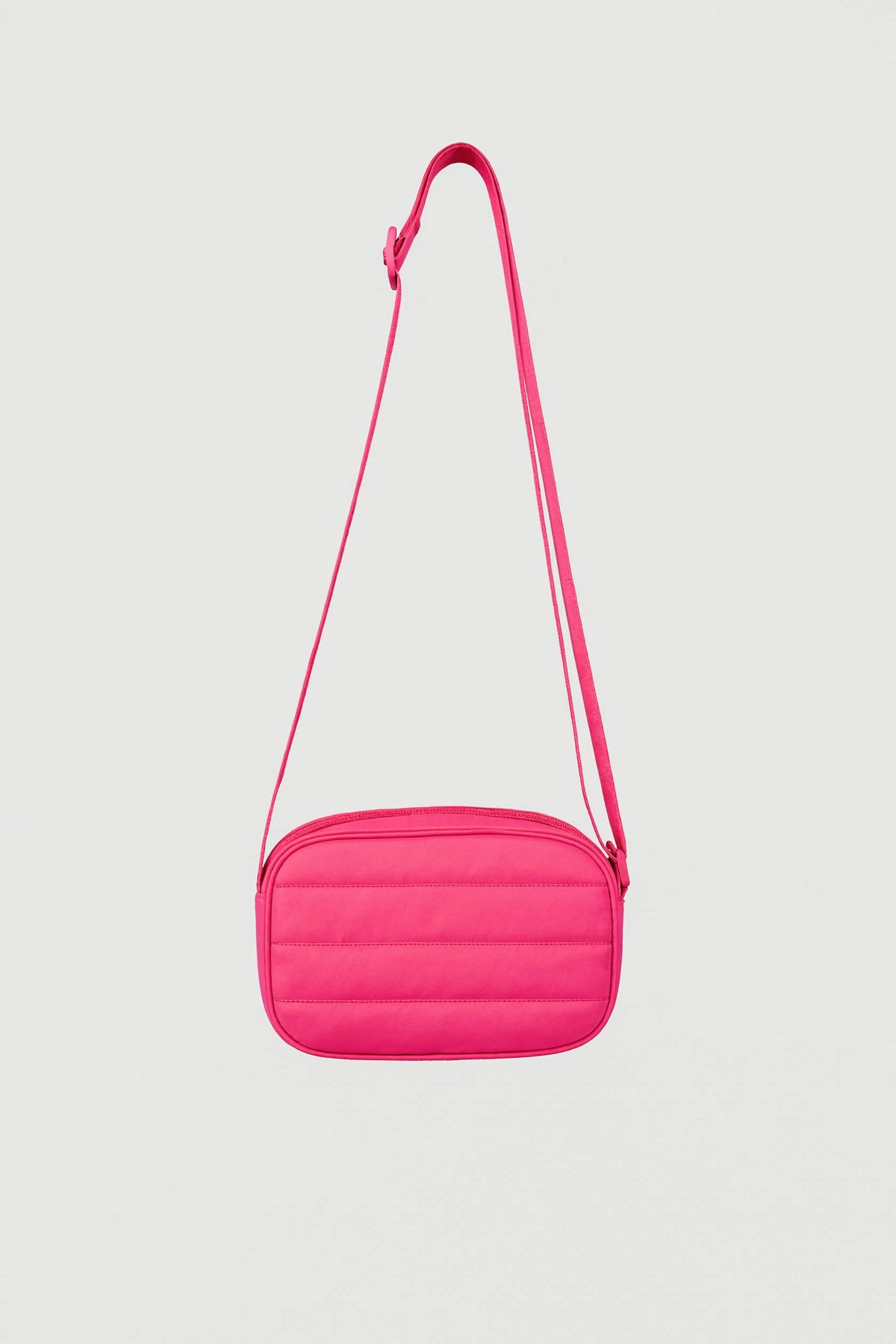 Bright pink padded crossbody bag with adjustable strap and zip closure against plain background