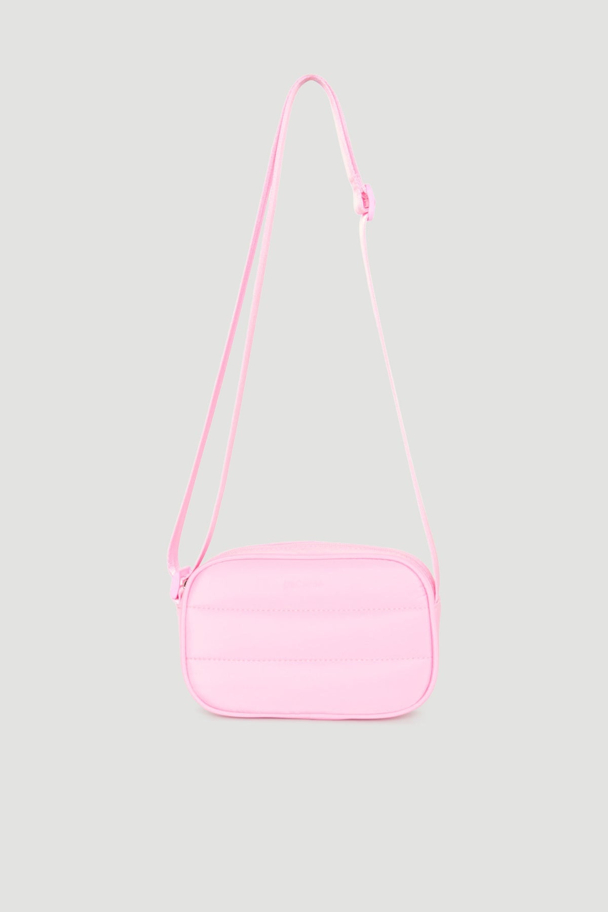 Soft pink padded crossbody bag with adjustable strap, designed for easy, stylish everyday wear.