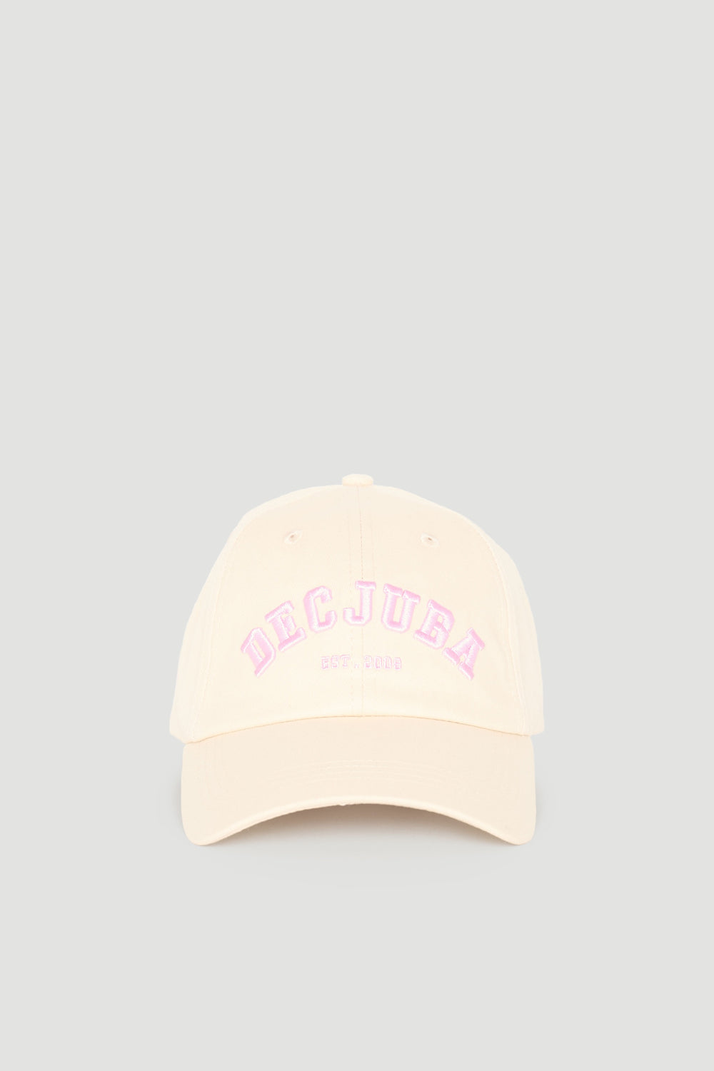 Cream-coloured girls varsity cap with soft pink embroidered logo, featuring a classic curved brim design.
