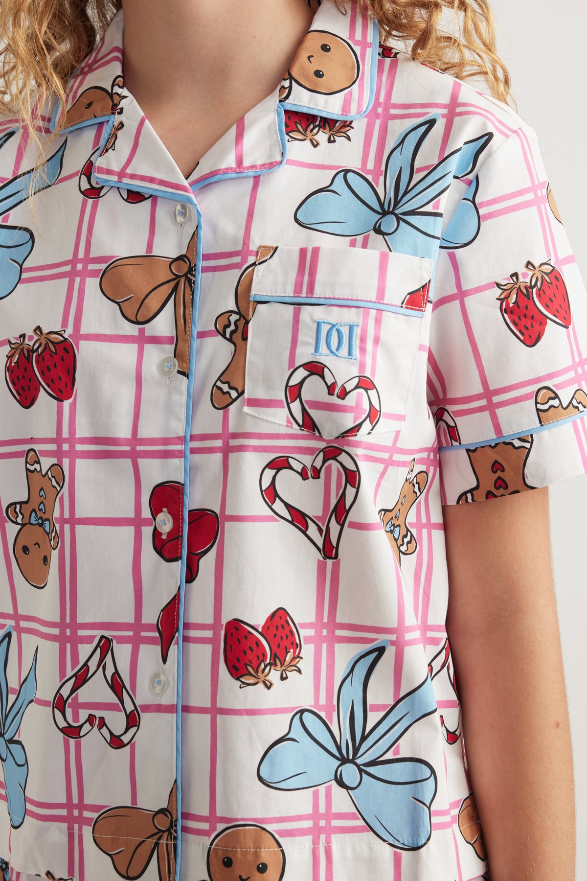 Girls short sleeve collared shirt with pink plaid, playful character prints and a button front