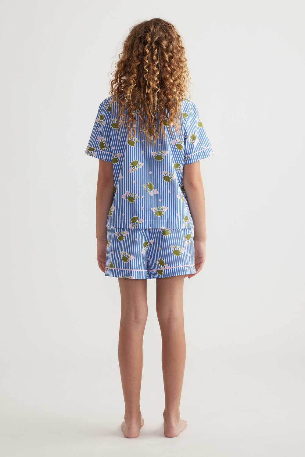 Back view of girl wearing a blue striped sleep set with a printed short sleeve shirt and matching shorts