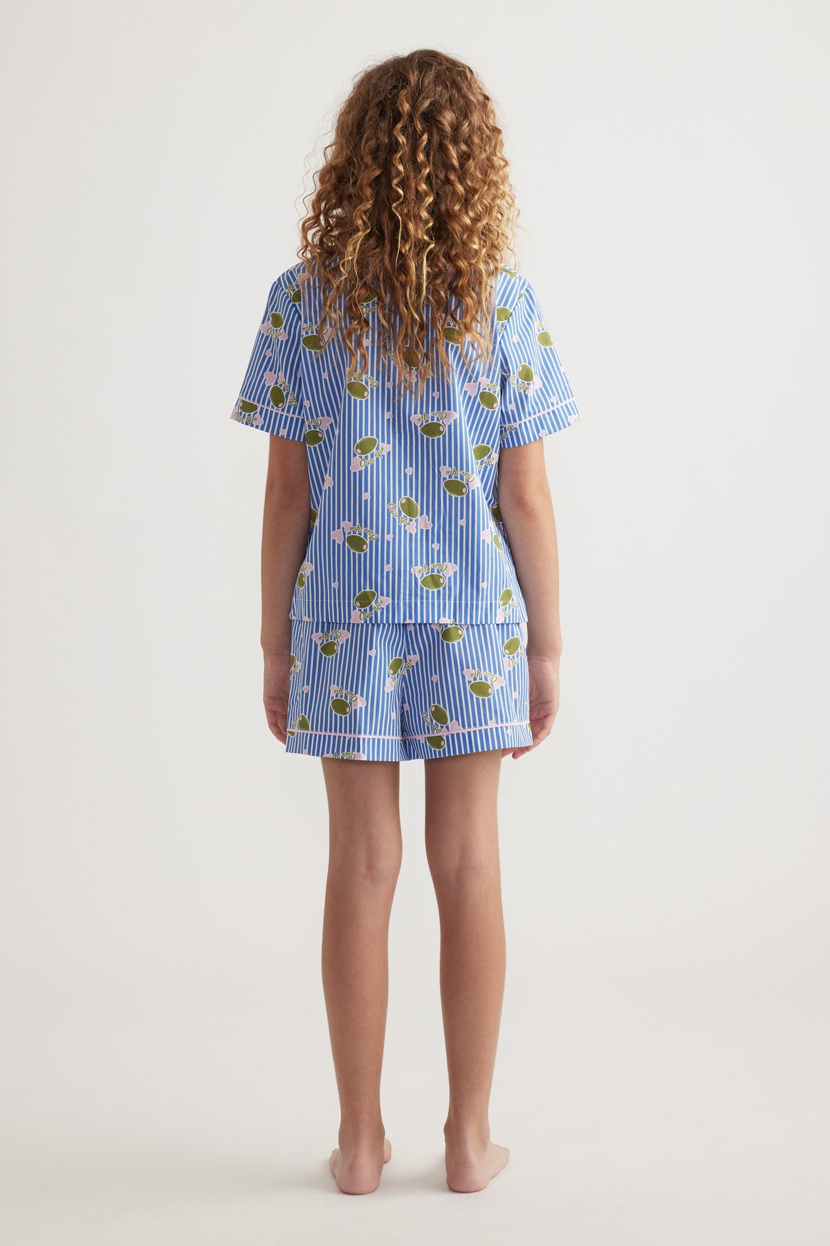 Back view of girl wearing a blue striped sleep set with a printed short sleeve shirt and matching shorts