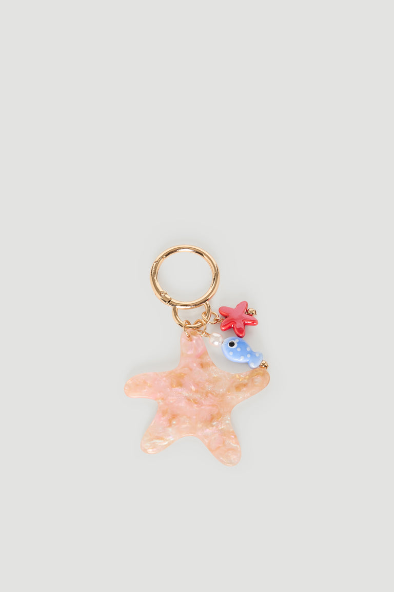 Gold keyring featuring a pink starfish charm with a small blue fish and red coral accents