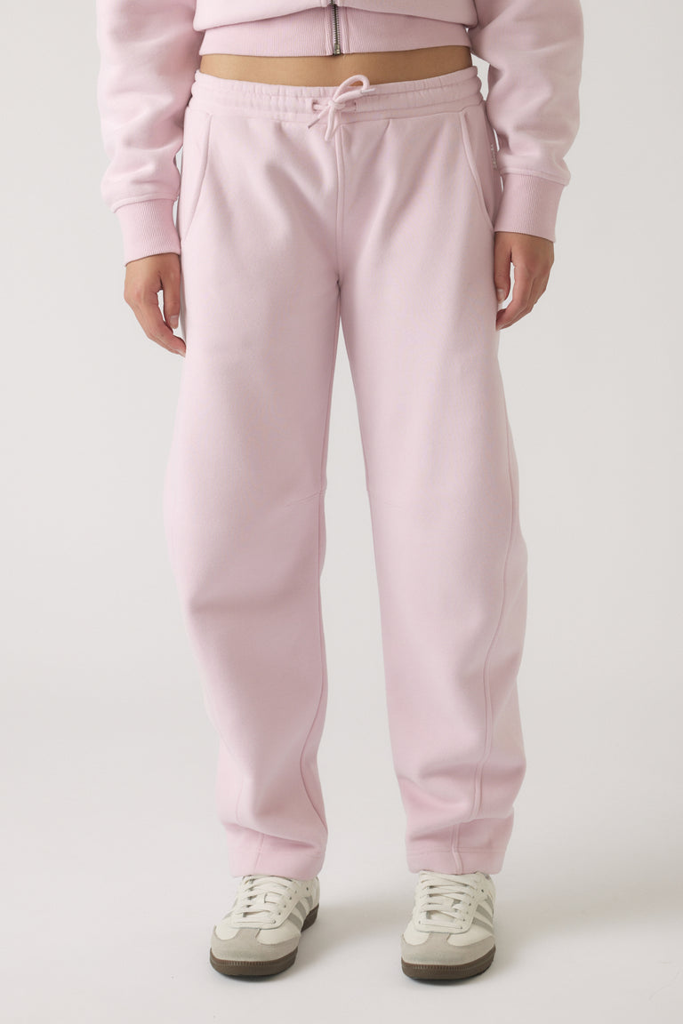 Girls wearing soft mauve barrel leg track pants styled with casual sneakers and a matching zip-up top