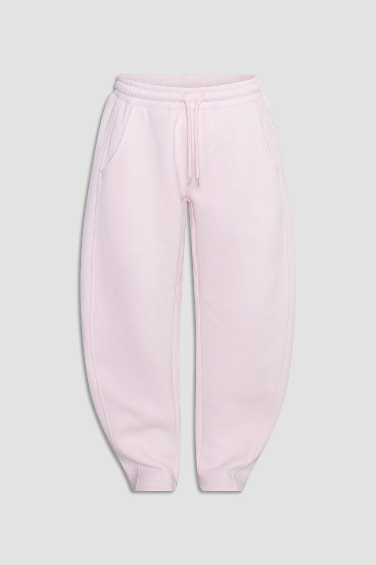 Light mauve relaxed barrel leg track pants for girls with an elastic waistband and side pockets on a plain background