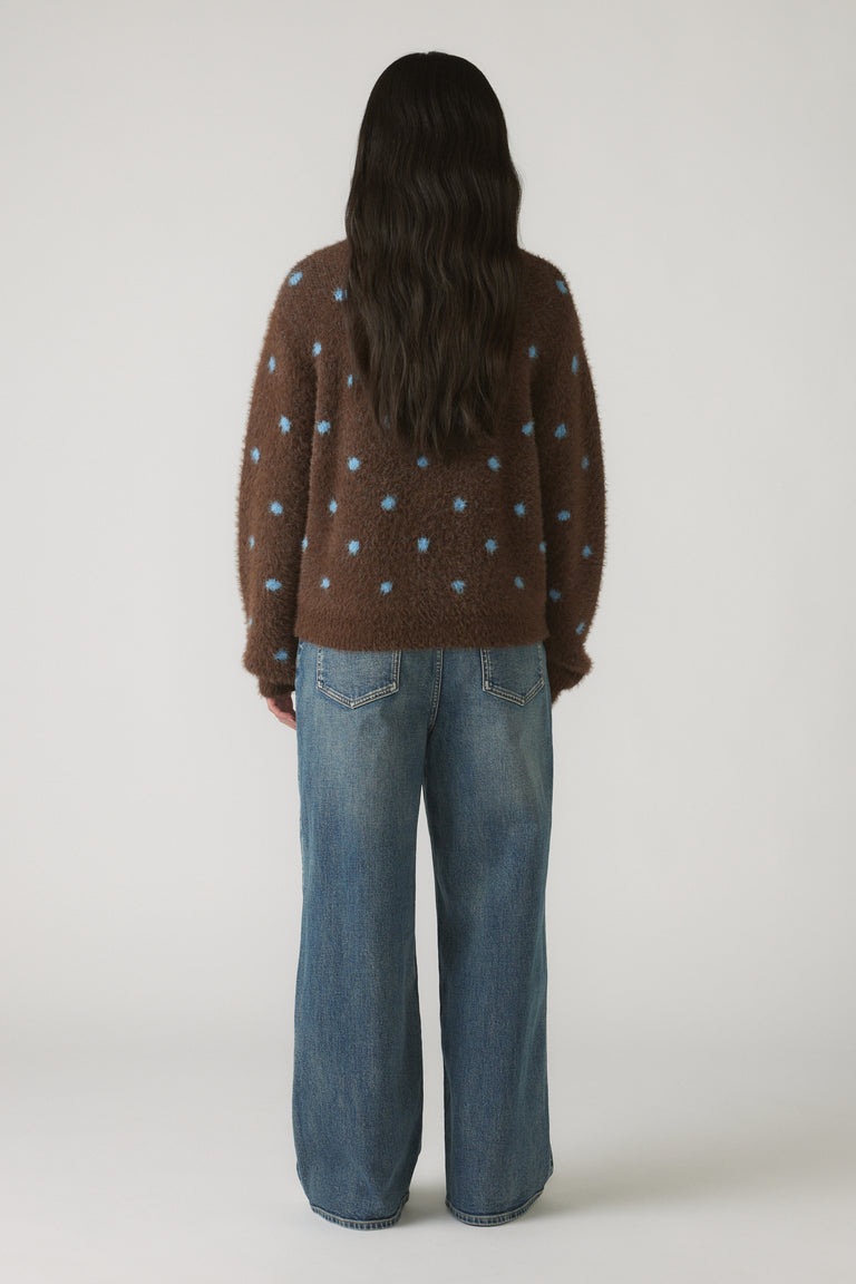 Back view of Girls Fluffy Crew Knit Jumper in brown with blue spots, paired with relaxed fit denim jeans for a casual look