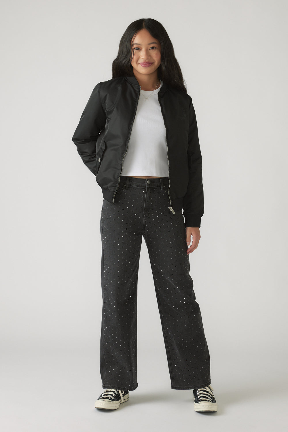 Girl modeling Girls Hailey Extra Long Jean in black denim with subtle sparkle detailing and a relaxed wide leg fit