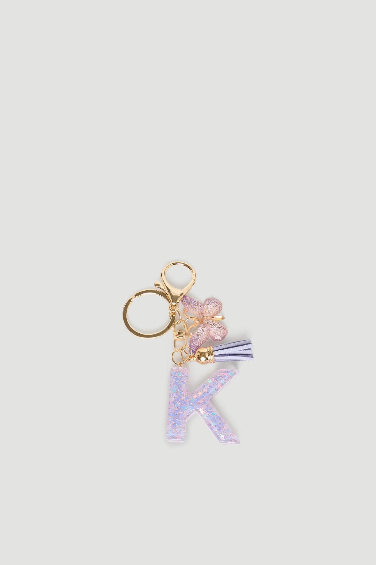 Girls Initial Key Ring featuring a glittery lavender letter K, pink floral charm, and soft purple tassel accessory.