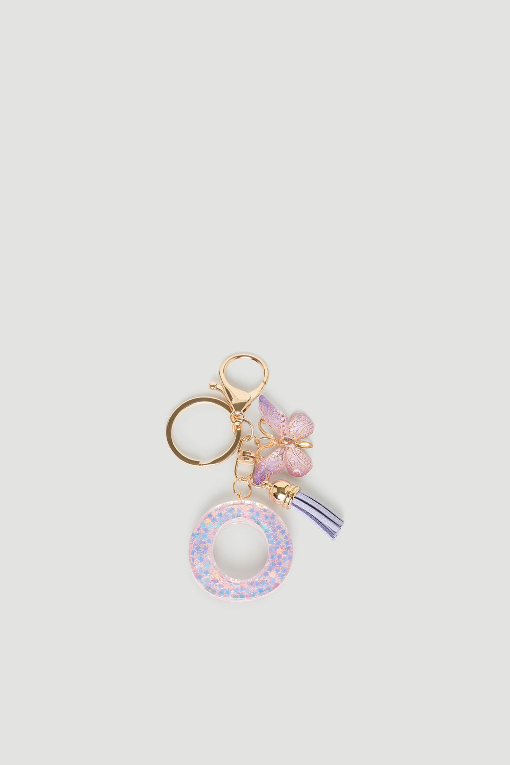 Girls Initial Key Ring featuring a glittery pastel letter O, delicate butterfly charm, and soft lilac tassel detail by DECJUBA.