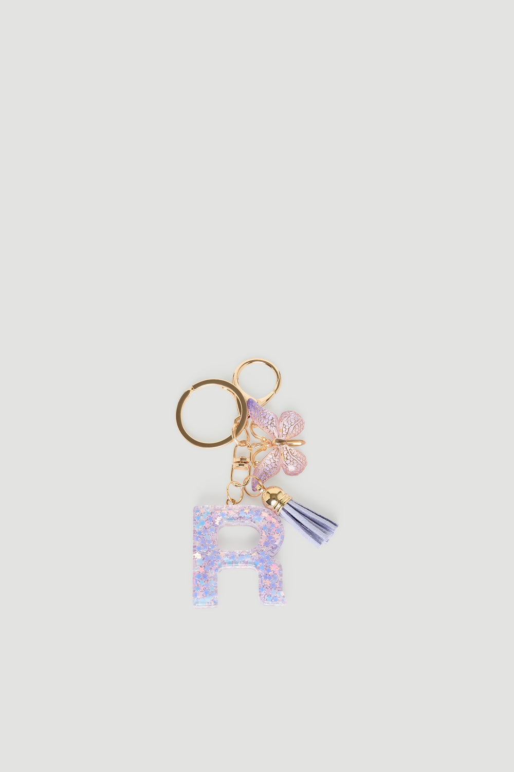 Girls Initial Key Ring featuring a glittery pastel letter R, delicate butterfly charm, and soft lilac tassel detail by DECJUBA.