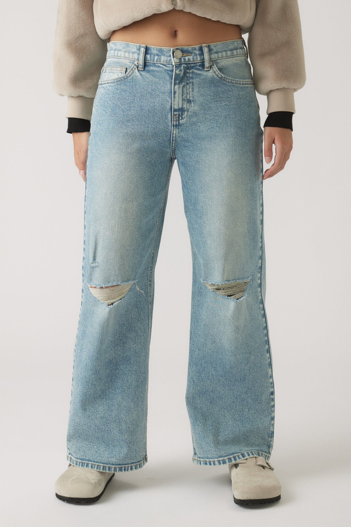 Light-wash denim jeans with a relaxed, baggy fit and ripped details at the knees for laid-back style.