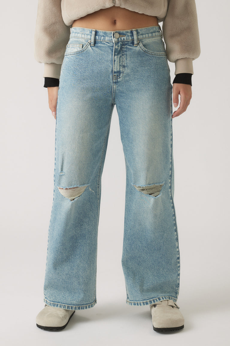 Light-wash denim jeans with a relaxed, baggy fit and ripped details at the knees for laid-back style.