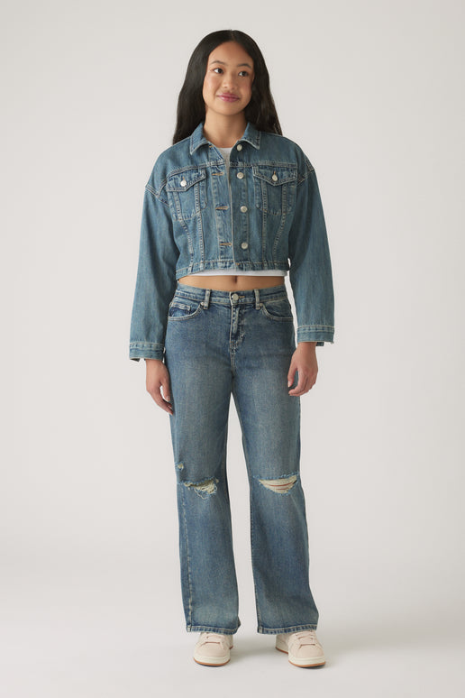 Girl wearing Girls Gigi Baggy Ripped Jean in classic blue denim paired with a cropped denim jacket and casual sneakers