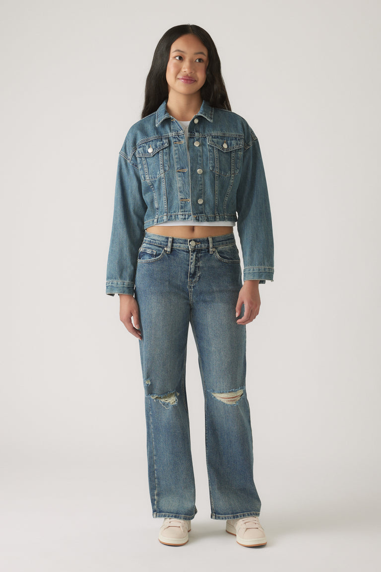 Girl wearing Girls Gigi Baggy Ripped Jean in classic blue denim paired with a cropped denim jacket and casual sneakers