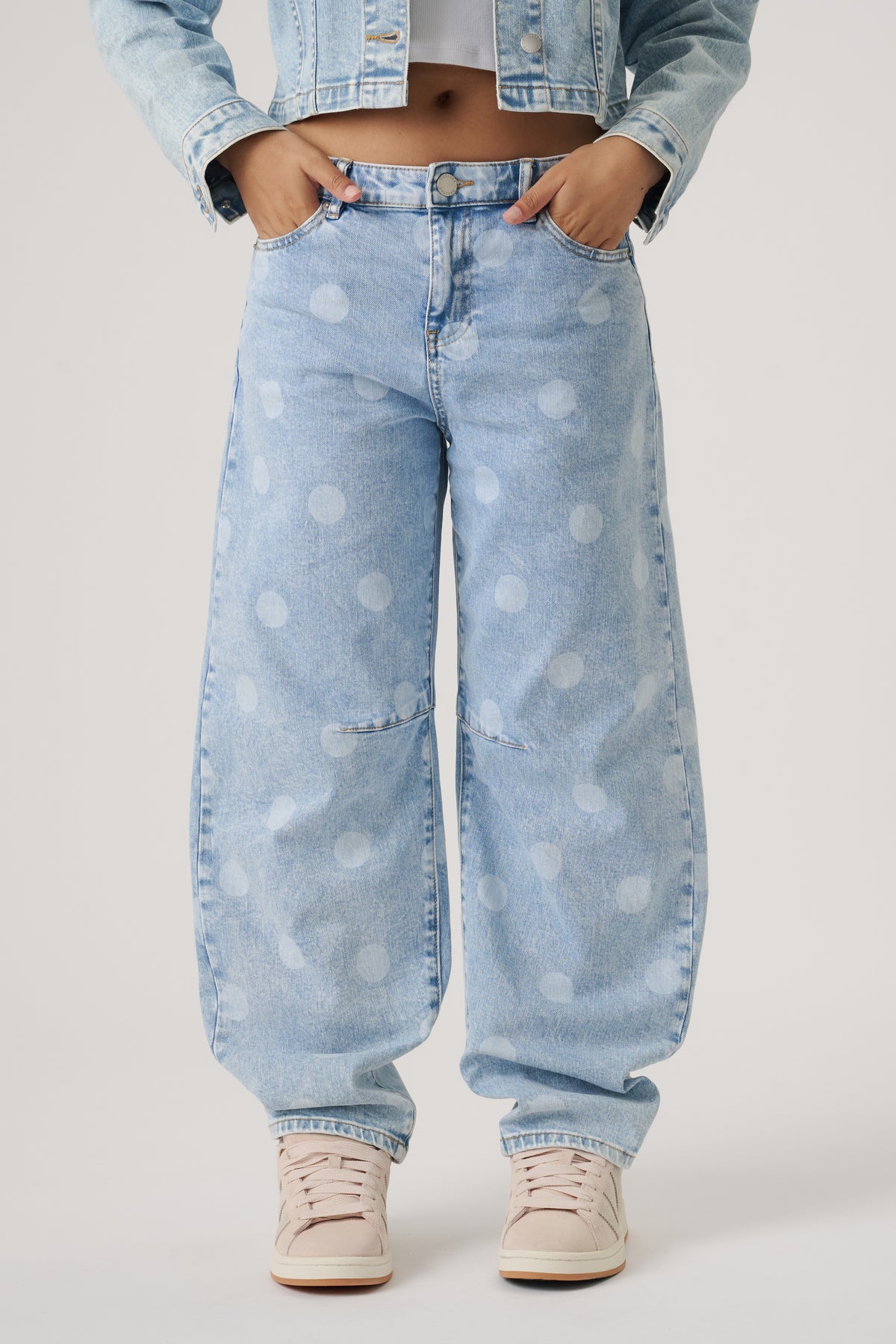 Light wash wide-leg jeans with subtle polka dots, worn with a cropped denim jacket and neutral sneakers.