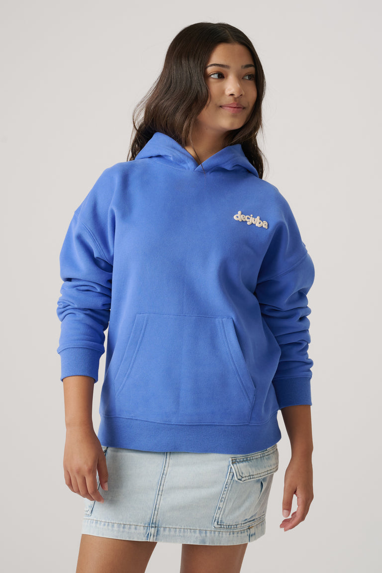 Girl wearing a relaxed cornflower blue oversized hoodie with logo embroidery paired with a light denim skirt
