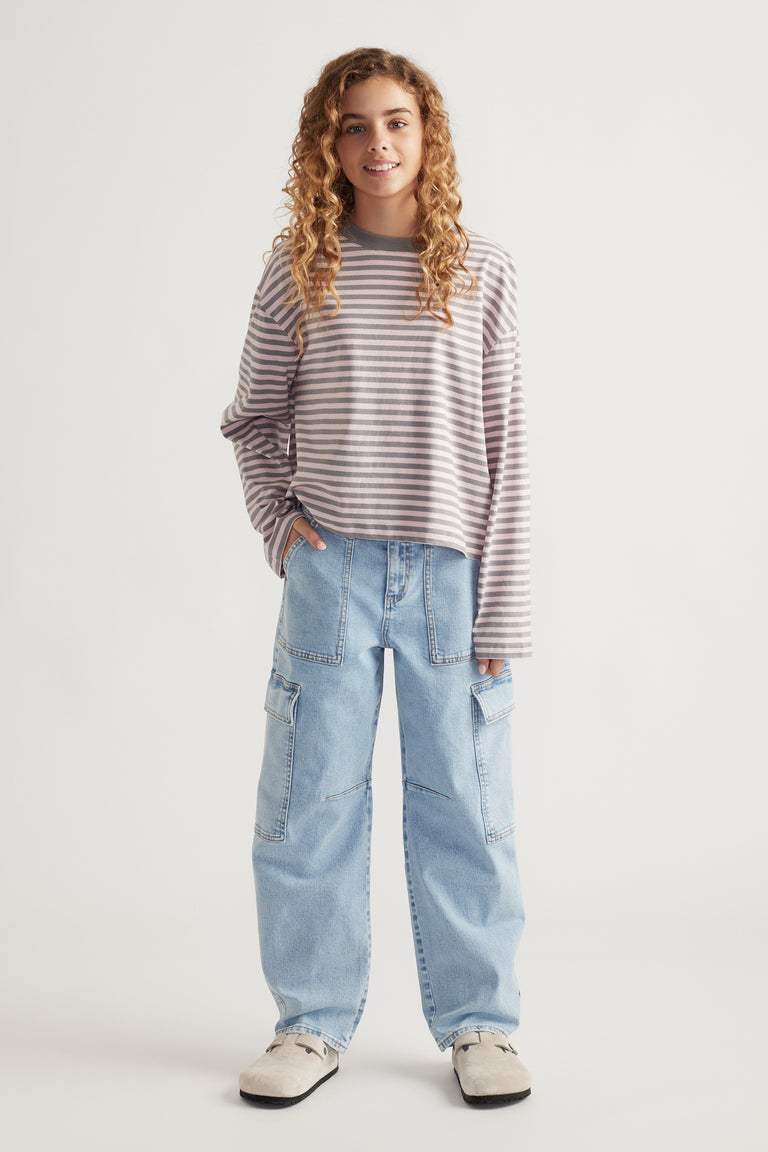 Girl wearing a relaxed fit striped long sleeve top paired with light blue wide-leg cargo jeans and casual shoes